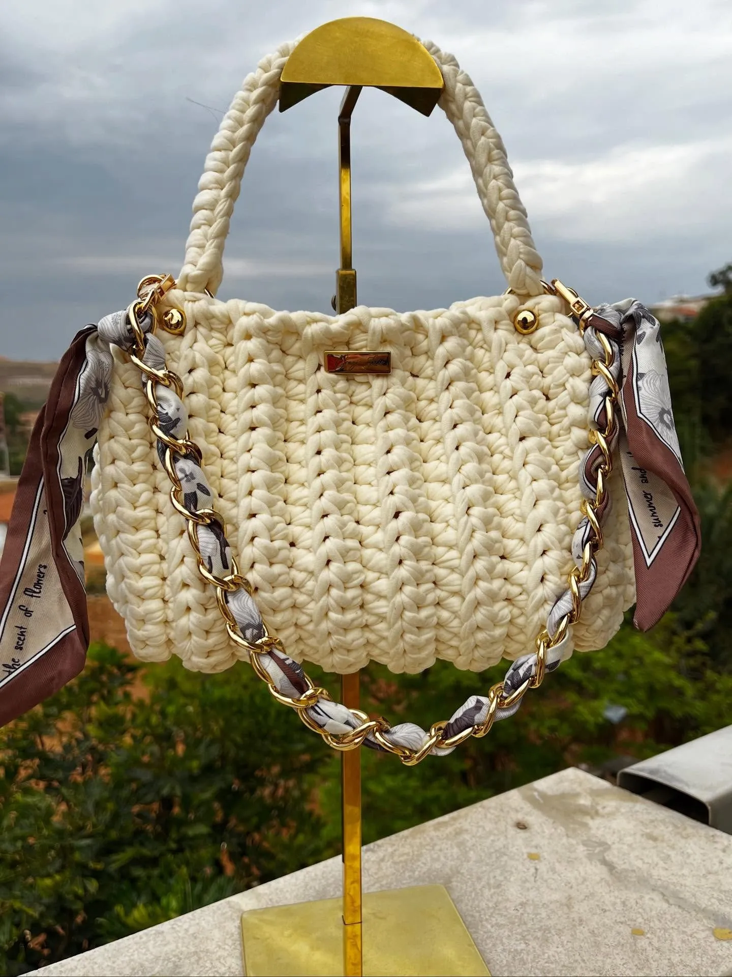Bolsa Cecília champanhe em crochê, com corrente dourada entrelaçada com lenço