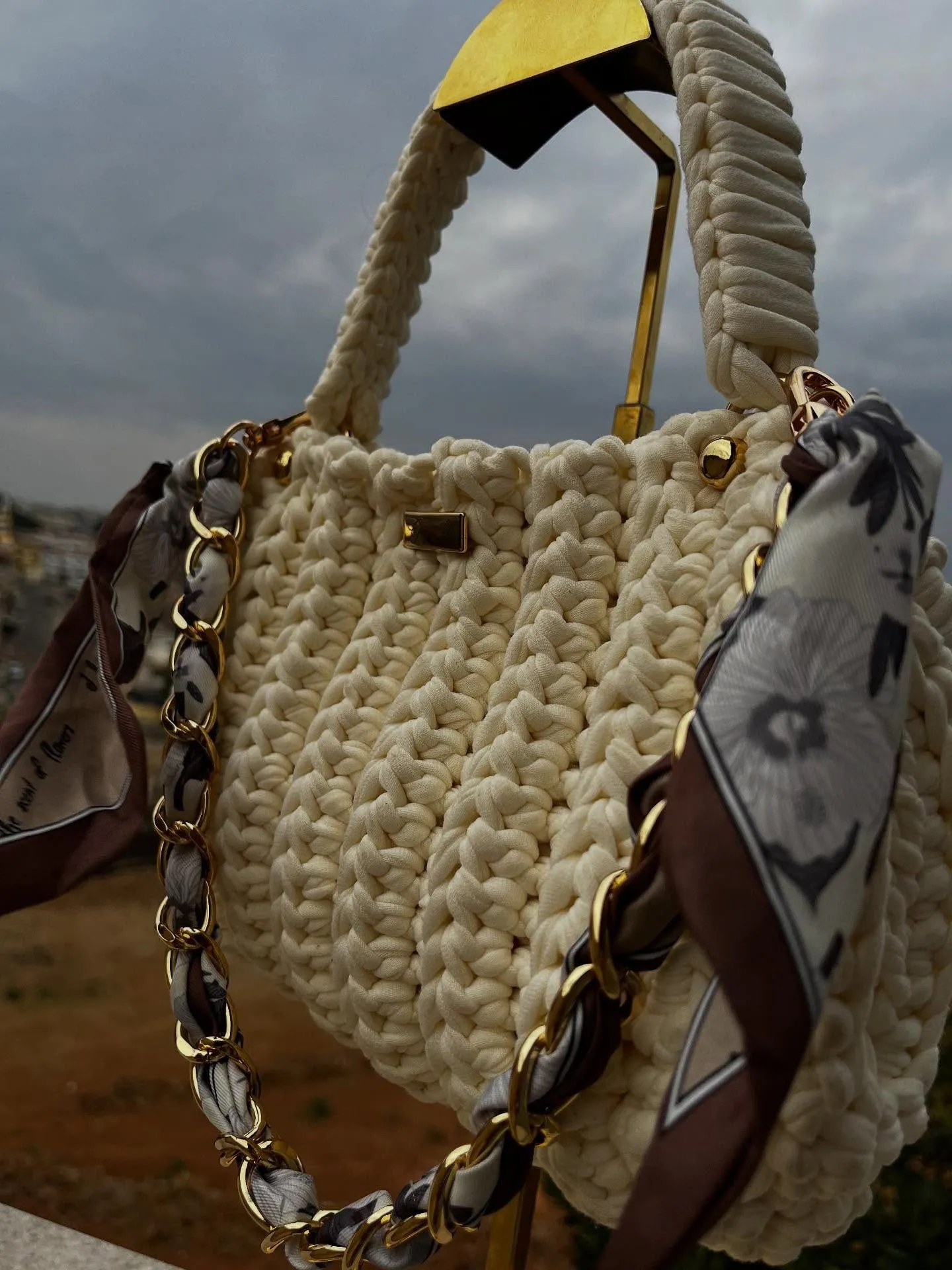 Bolsa Cecília vista de perto, com o lenço estampado e a corrente