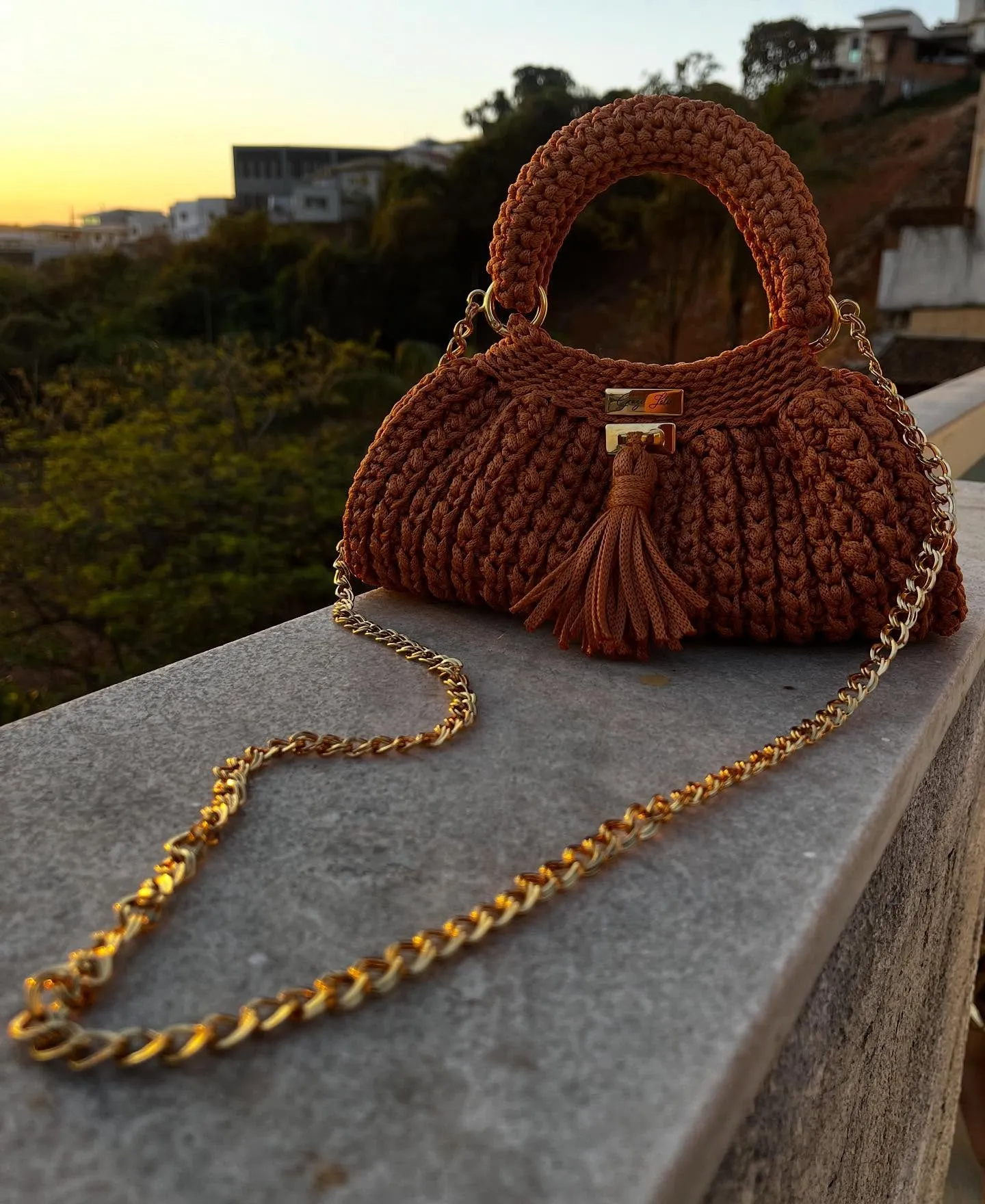 Bolsa Crochê de Festa marrom, com alça de mão, tassel e corrente dourada, vista de frente