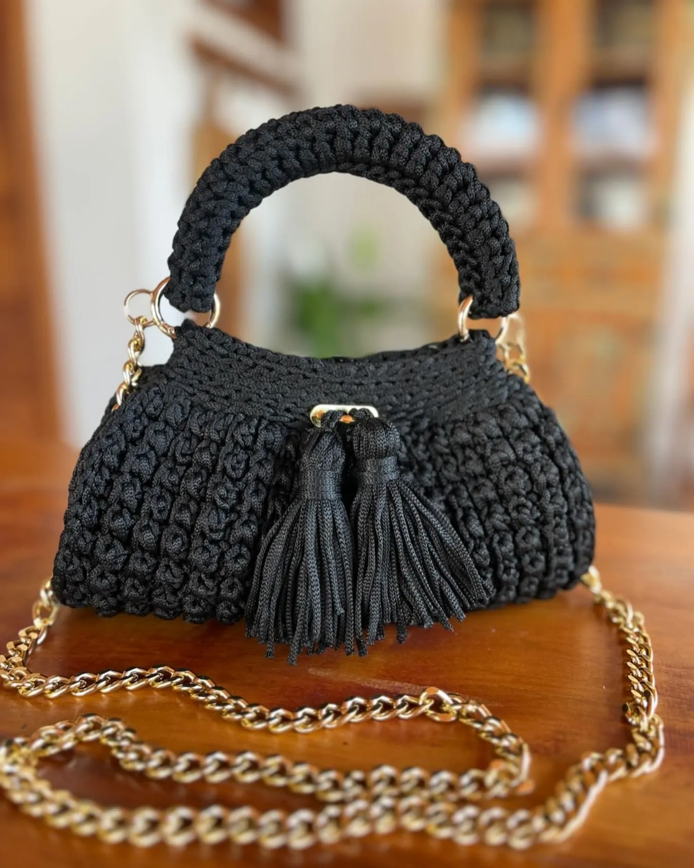 Bolsa Crochê de Festa preta, com alça de mão, dois tassels e corrente dourada