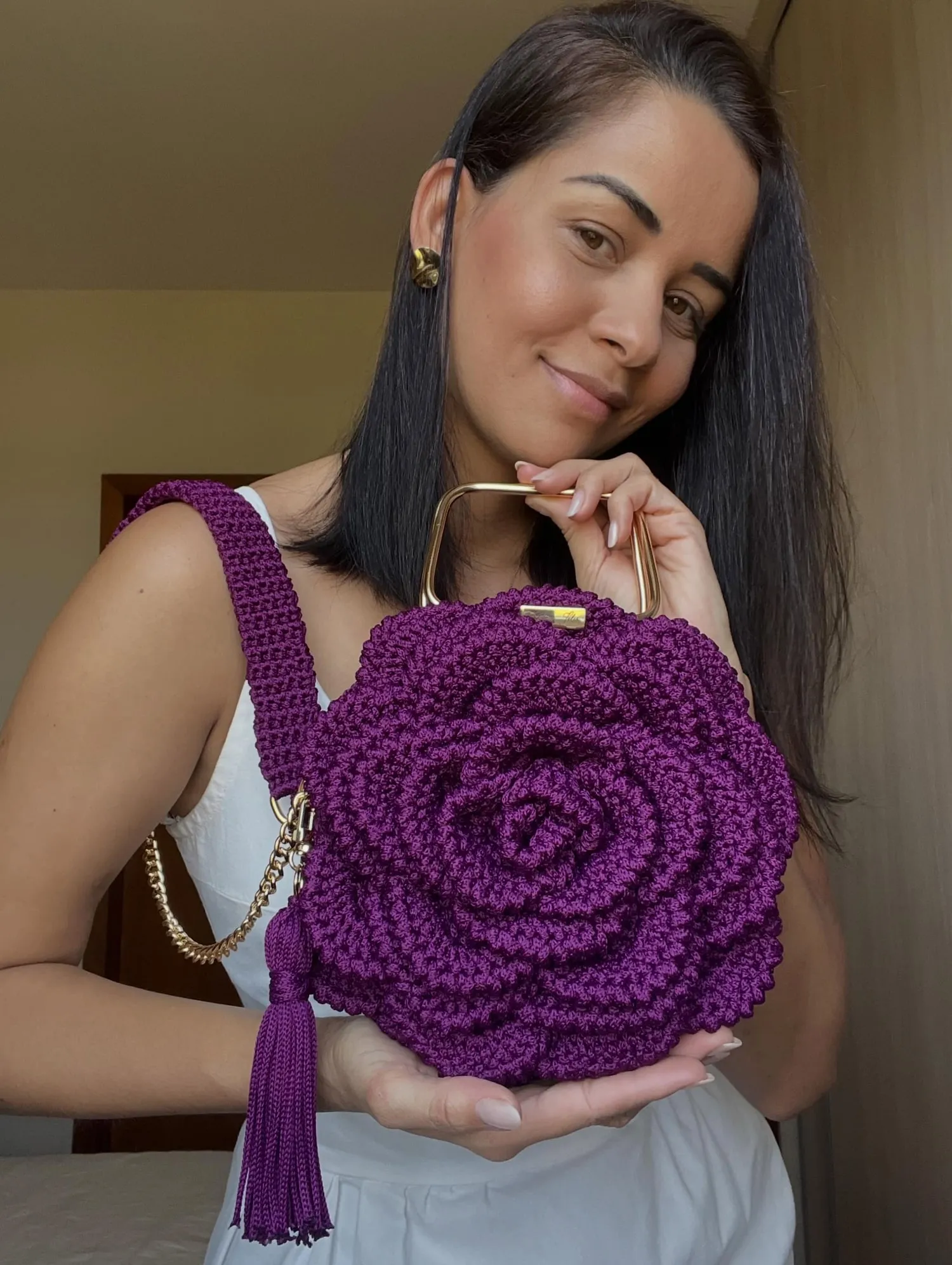 Woman holding the purple Flower Bag, with a crochet shoulder strap