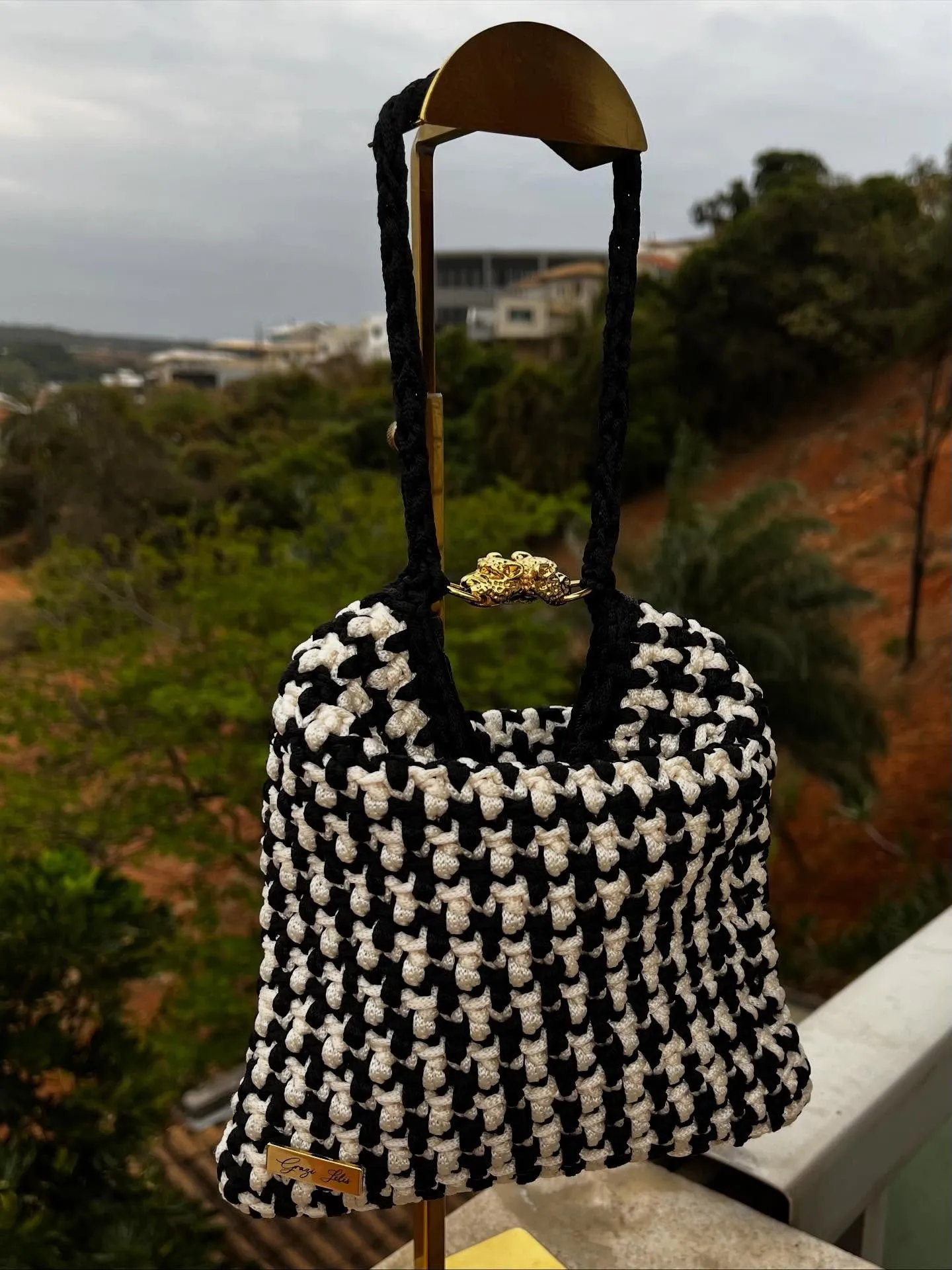 Bolsa Uau em crochê pied-de-poule preto e creme, com alças trançadas pretas e fecho dourado