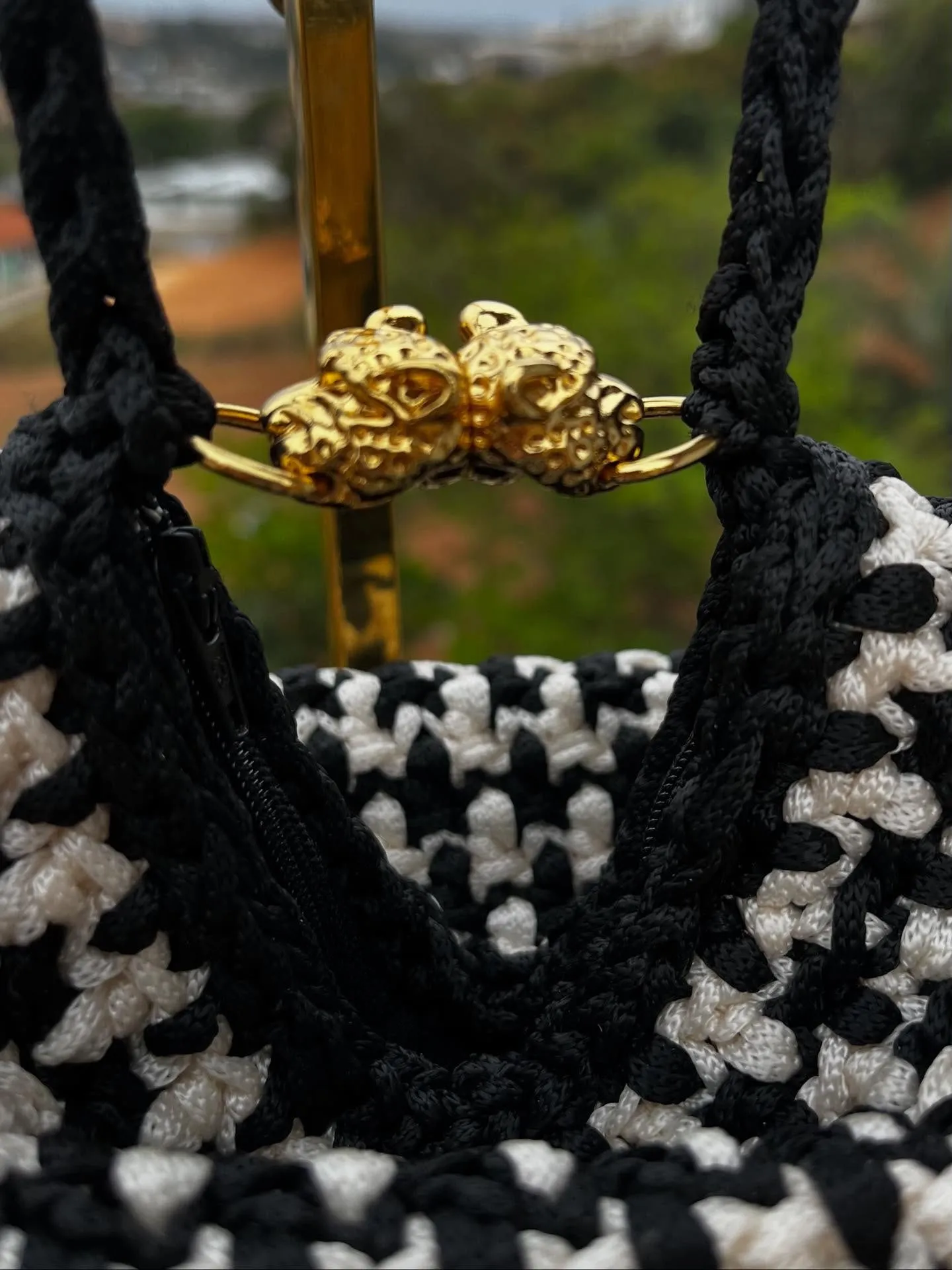 Detalhe do fecho dourado em formato de tigre da Bolsa Uau
