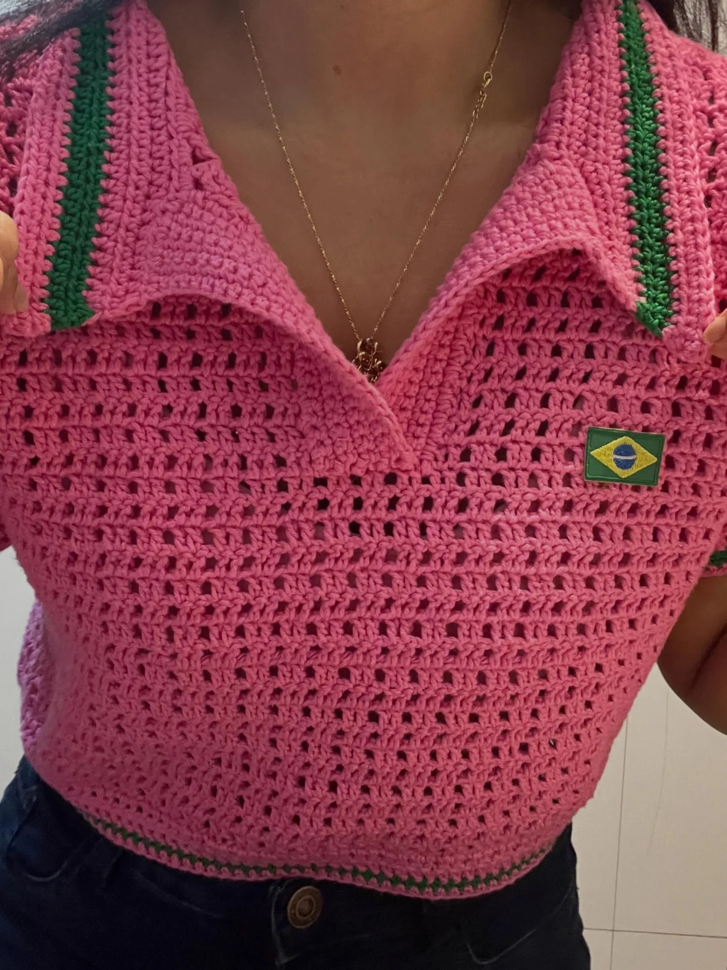 Detalhe da gola polo com friso verde e da bandeira do Brasil